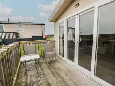 a patio with chairs and a table on a deck at Peaceful in Stranraer