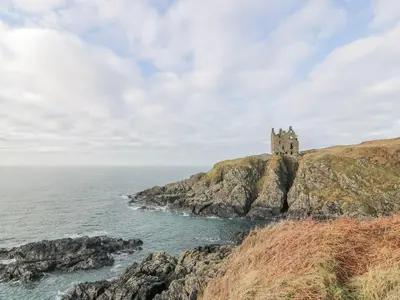 a castle on a cliff next to the ocean at Ellies House in Stranraer