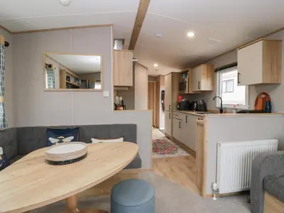 a kitchen and a living room with a table in a room at Ellies House in Stranraer