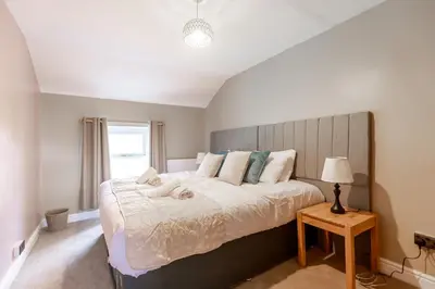 a bedroom with a large bed and a window at EASTCOTE FARM - Spacious 5-Bed Home with Views, Garden & Playroom in Silloth