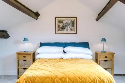 a bedroom with a bed and two night stands at Springholm Cottage Family Retreat - Sleeps 10 in Bootle