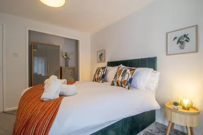 a bedroom with a large bed with white sheets and pillows at Corsehill Cottage - 3 Bedroom, 2 bathroom House in Dreghorn