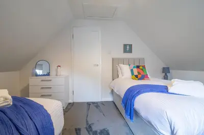 a bedroom with two beds and a dresser at Corsehill Cottage - 3 Bedroom, 2 bathroom House in Dreghorn