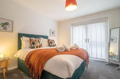 a bedroom with a large bed with towels on it at Corsehill Cottage - 3 Bedroom, 2 bathroom House in Dreghorn