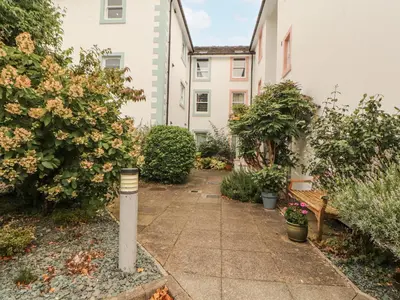 a garden with a parking meter in front of some buildings at Flat 17 Greta Grove in Keswick