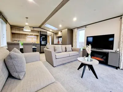 a living room with couches and a flat screen tv at Landal Ullswater Heights in Great Blencow