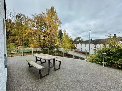 a picnic table and a bench on a patio at Jaytrees, Keswick - Luxury bungalow with hot tub in Keswick