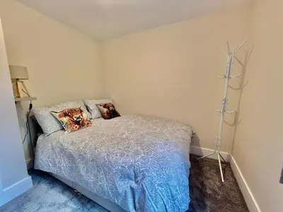 a bedroom with a bed with pillows on it at Jaytrees, Keswick - Luxury bungalow with hot tub in Keswick