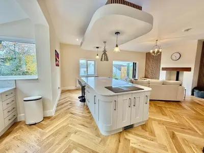 a kitchen with a white island in a living room at Jaytrees, Keswick - Luxury bungalow with hot tub in Keswick