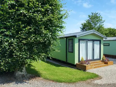 a green holiday home with a tree at Melfell View - Uk50086 in Penruddock