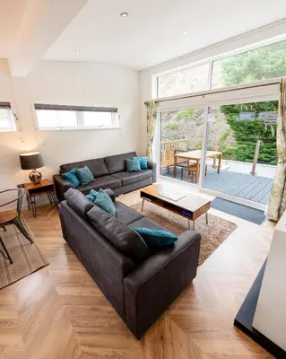 a living room with a couch and a table at Great Gable Riverside Luxury Lodge in Keswick