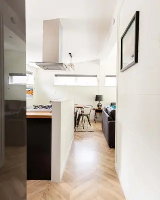 a kitchen and living room with white walls and wood floors at Great Gable Riverside Luxury Lodge in Keswick