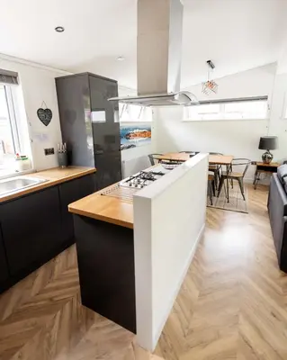 a kitchen with a stove and a counter top at Great Gable Riverside Luxury Lodge in Keswick