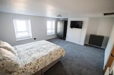 a bedroom with a bed and a flat screen tv at Cottage in Seaton in Siddick