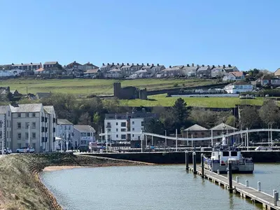 a boat is docked at a dock on a river at Lovely 2BED Whitehaven Apartment with Sea Views in Whitehaven