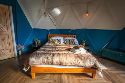 a bedroom with a large bed in a tent at Coorie Retreats Luxury Geo Domes and Cabins with Private Hot Tubs Cinema Firepit Spa and More in Portpatrick