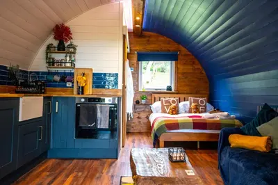 a living room with a couch and a bed in a house at Coorie Retreats Luxury Geo Domes and Cabins with Private Hot Tubs Cinema Firepit Spa and More in Portpatrick