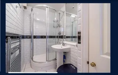 a white bathroom with a sink and a shower at 14 Maple Mews in Moffat