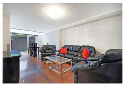 a living room with a leather couch and a table at 14 Maple Mews in Moffat