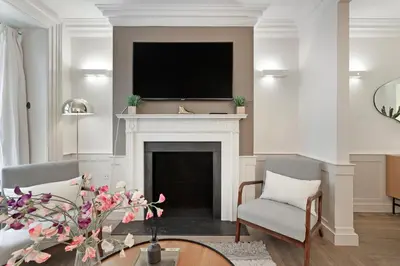 a living room with a fireplace with a flat screen tv at Arcore London Premium Apartment Liverpool Street in Moffat