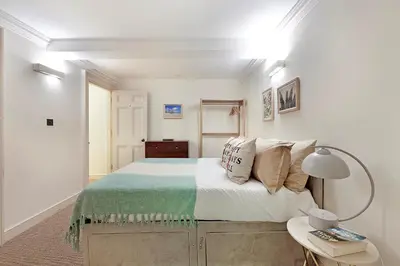 a white bedroom with a bed and a table at Arcore London Premium Apartment Liverpool Street in Moffat