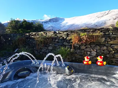 two rubber ducks sitting next to a water fountain at 2 Double Bed Cottage Hottub Lake District Keswick in Keswick