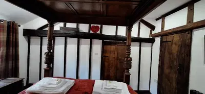 a bedroom with a wooden bed with a canopy at 2 Double Bed Cottage Hottub Lake District Keswick in Keswick