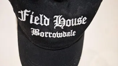 a black baseball cap with the words hello joustles bombardiable at 2 Double Bed Cottage Hottub Lake District Keswick in Keswick