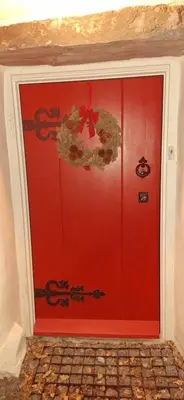 a red door with a christmas wreath on it at 2 Double Bed Cottage Hottub Lake District Keswick in Keswick