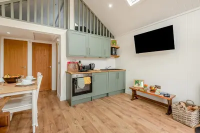 a kitchen with green cabinets and a table and a tv at 2 Bed in Mouswald oc-b33444 in Mouswald
