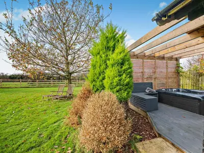 a garden with a bench and a pine tree at 1 Bed in Dearham 96373 in Dearham