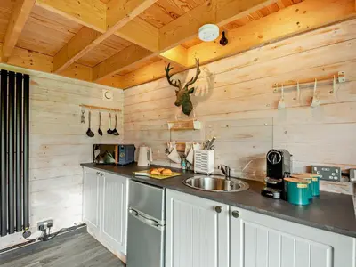 a kitchen with wooden walls and a counter with a sink at 1 Bed in Dearham 96373 in Dearham