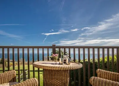 a table on a balcony with a view of the ocean at Spacious holiday home with stunning sea views in Whiting Bay