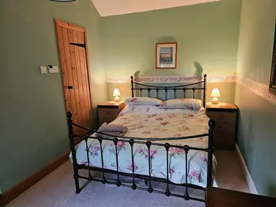 a bedroom with a bed and two night stands and two lamps at Morton Mains Cottage