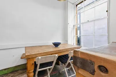 a wooden table in a room with a window at Charming Central Stay in Moffat