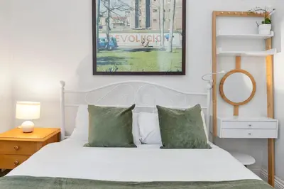 a bedroom with a white bed with green pillows at Charming Central Stay in Moffat