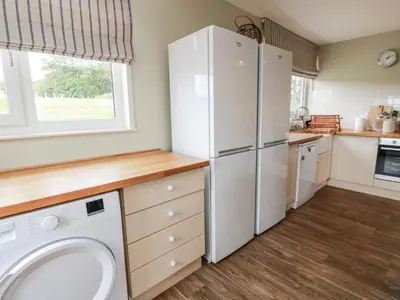 a kitchen with white appliances and a washer and dryer at The Dairy in Newton Stewart