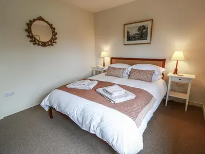 a bedroom with a bed with two towels on it at The Dairy in Newton Stewart