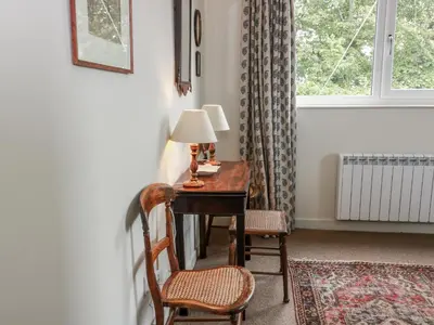 a room with a desk with two chairs and a window at The Dairy in Newton Stewart