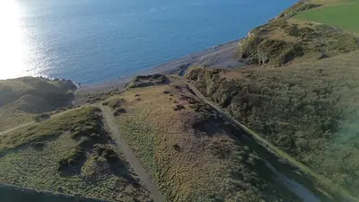 an aerial view of a road on a mountain next to the ocean at The Dairy in Newton Stewart