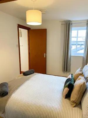 a bedroom with a large bed with a window at Hadrians Retreat, Cosy 1 Bed Flat - near M6 Jct45, A75, Gretna & Carlisle in Longtown