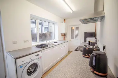a kitchen with a washing machine and a sink at Your Perfect Home Away From Home in Workington