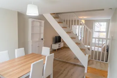 a kitchen and dining room with a table and a staircase at Your Perfect Home Away From Home in Workington
