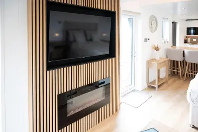 a living room with a flat screen tv on a wall at Ardwall in Carsluith