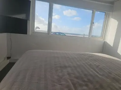 a bedroom with a bed with a large window at Sandylands in Braystones