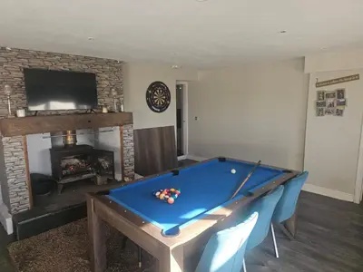 a living room with a pool table and a fireplace at Sandylands in Braystones