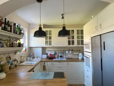 a kitchen with white cabinets and black pendant lights at Luxury Spacious Double Room, Mill Hill, London NW7 3BD in Moffat