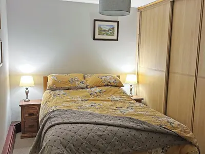 a bed in a bedroom with two lamps on tables at Quarry's Edge in Chapel Stile