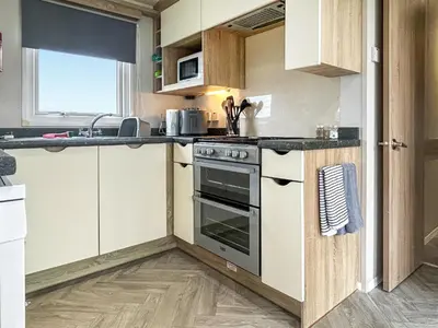 a kitchen with a stove and a sink at Coastal Bay View in Ayr
