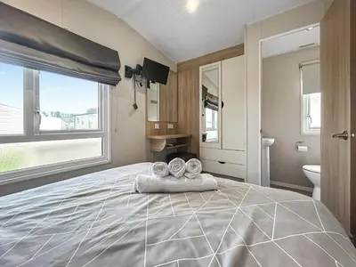 a bedroom with a large bed with towels on it at Coastal Bay View in Ayr